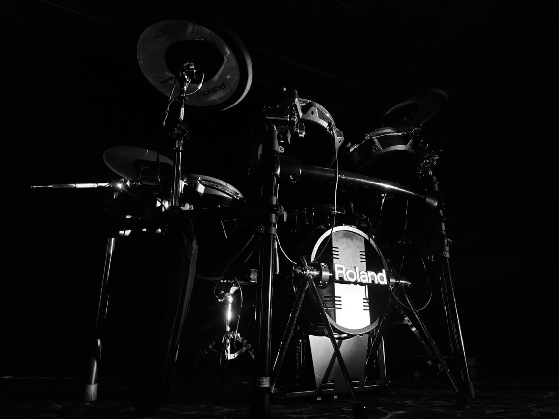 drums played by humans Schwarz-weißes Schlagzeug vor dunklem Hintergrund.