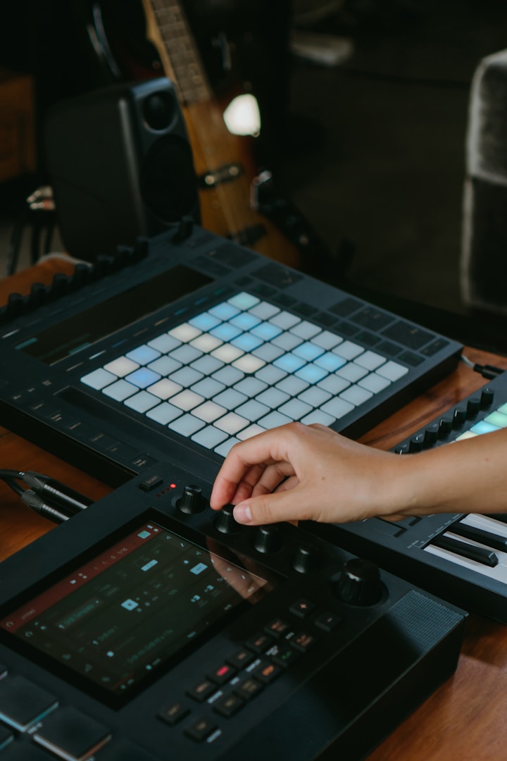 sample and sound production Hand bedient ein Musikgerät mit Tasten und Reglern auf einem Holztisch.